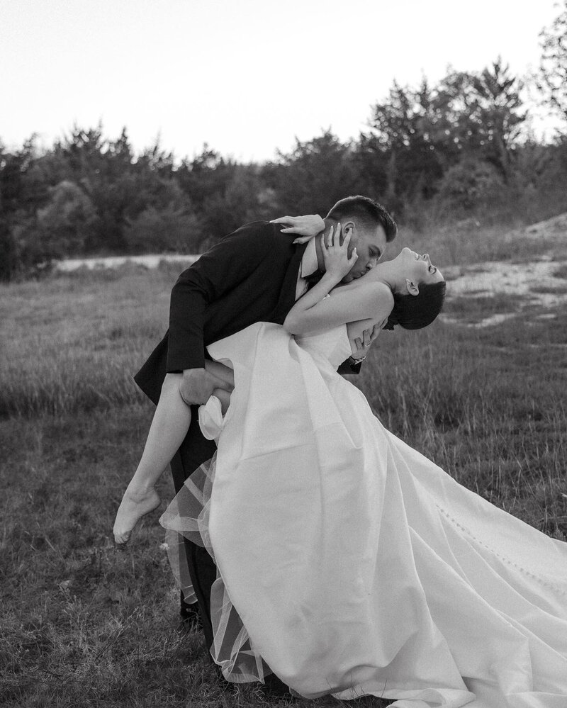 Editorial black and white wedding portrait of bride and groom dancing outdoors in Oklahoma – photographed by Madison Dodd Photo