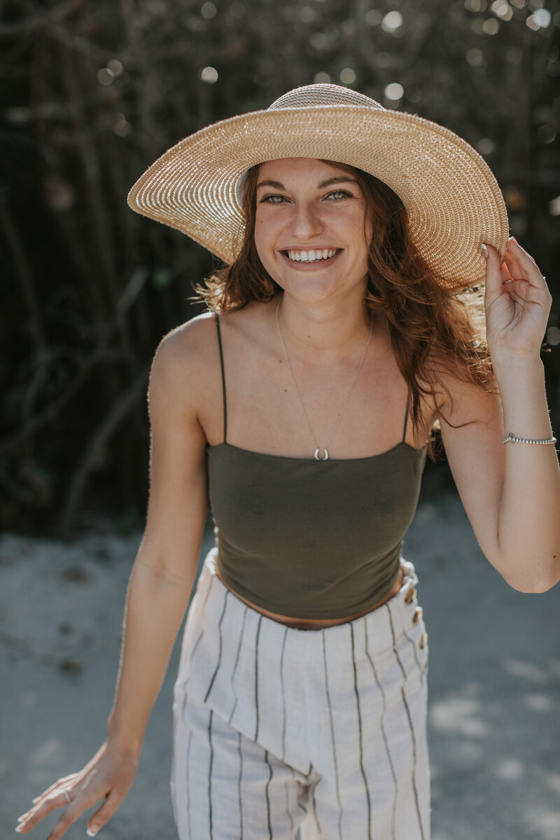 Headshot of a woman smiling with a sunhat at the beach in Jupiter, Florida.