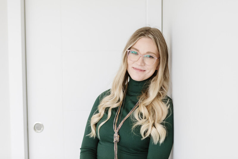 Realtor Tamara leaning against the wall in a pristine white home