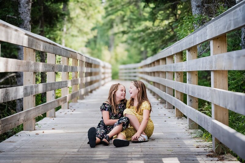 twin-sisters-laughing-on-a-bridge