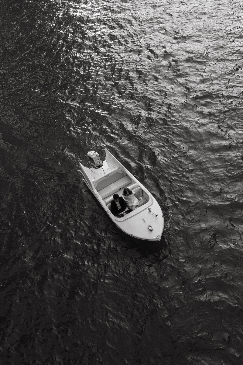 Aerial view of a boat gliding through calm waters, offering a serene and adventurous moment for a couple's wedding or engagement shoot.