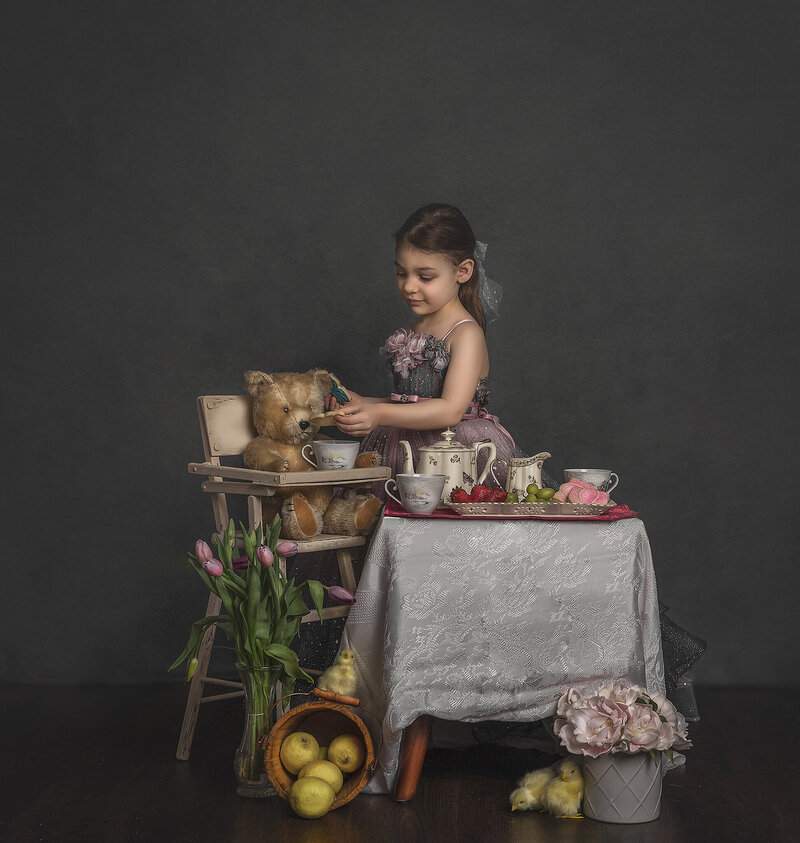"Children enjoying a whimsical tea party, captured in a delightful portrait session with tea sets and playful props in Ottawa."
