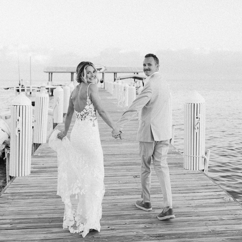 Bride and groom walking hand in hand on a dock at Cheeca Lodge Resort, captured by Claudia Amalia, a Miami-based wedding photographer specializing in destination weddings.