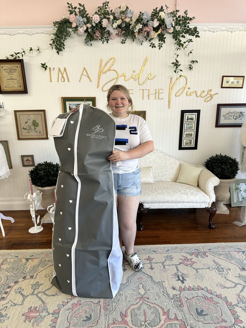 bride holding her wedding dress in aberdeen NC wedding dress shop