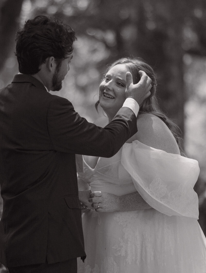 Couple portrait of groom wiping a tear from his brides face  