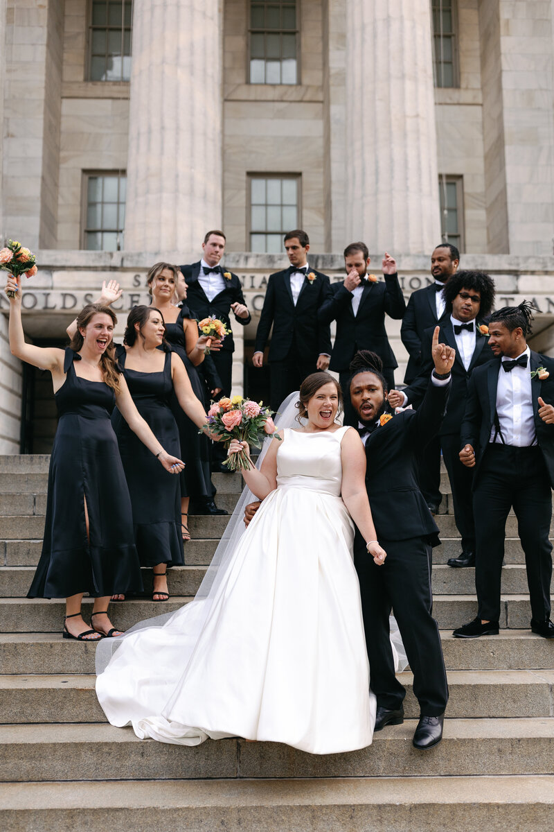 A classy wedding party lines the steps of the National Portrait Gallery in Washington DC