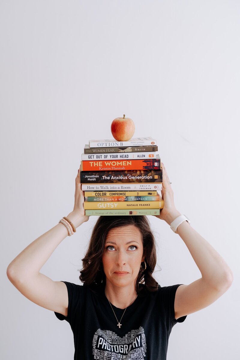Carrie balancing a stack of books on her head