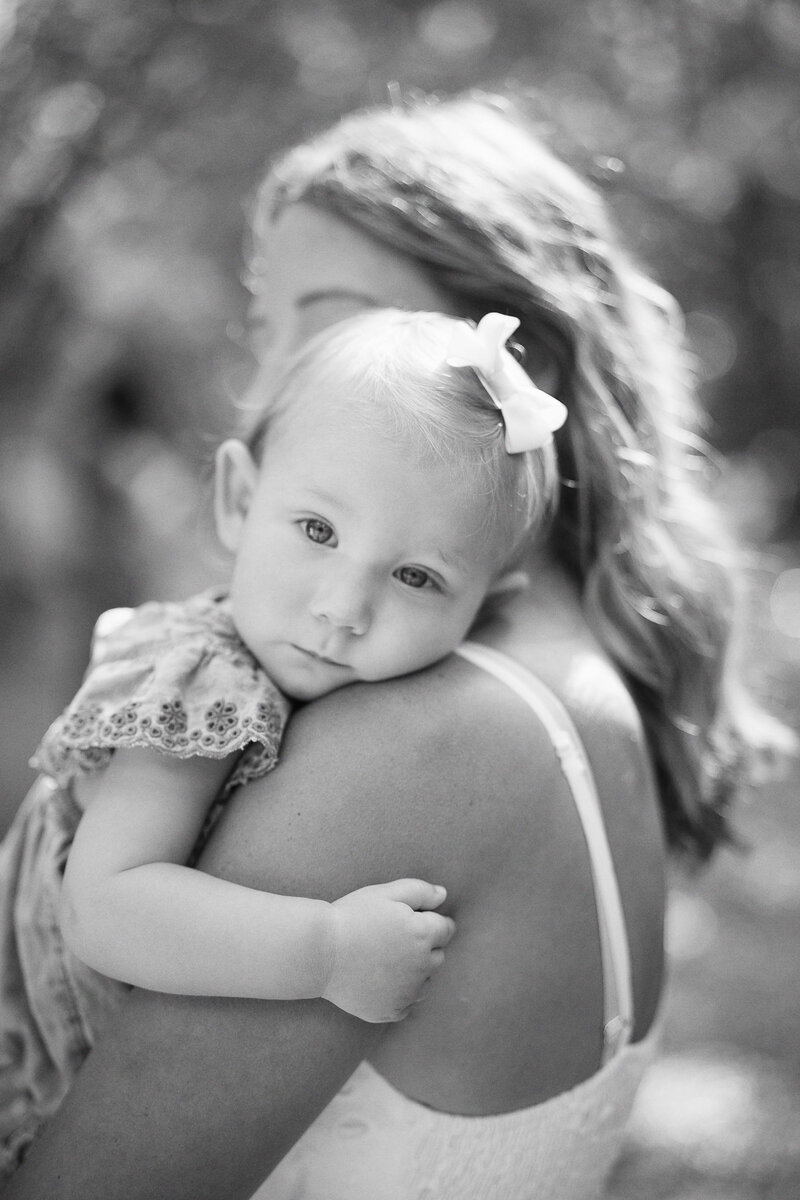 daughter resting head on mom's shoulder