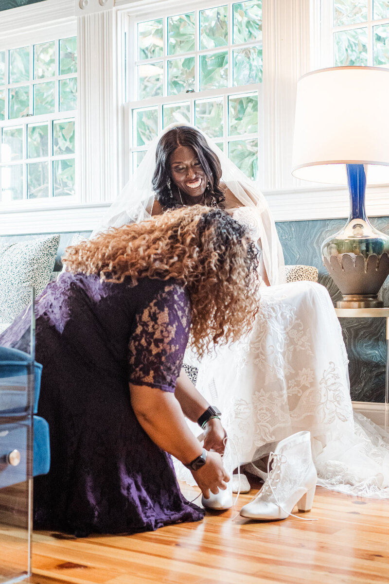 Mother fixing the shoes of the bride
