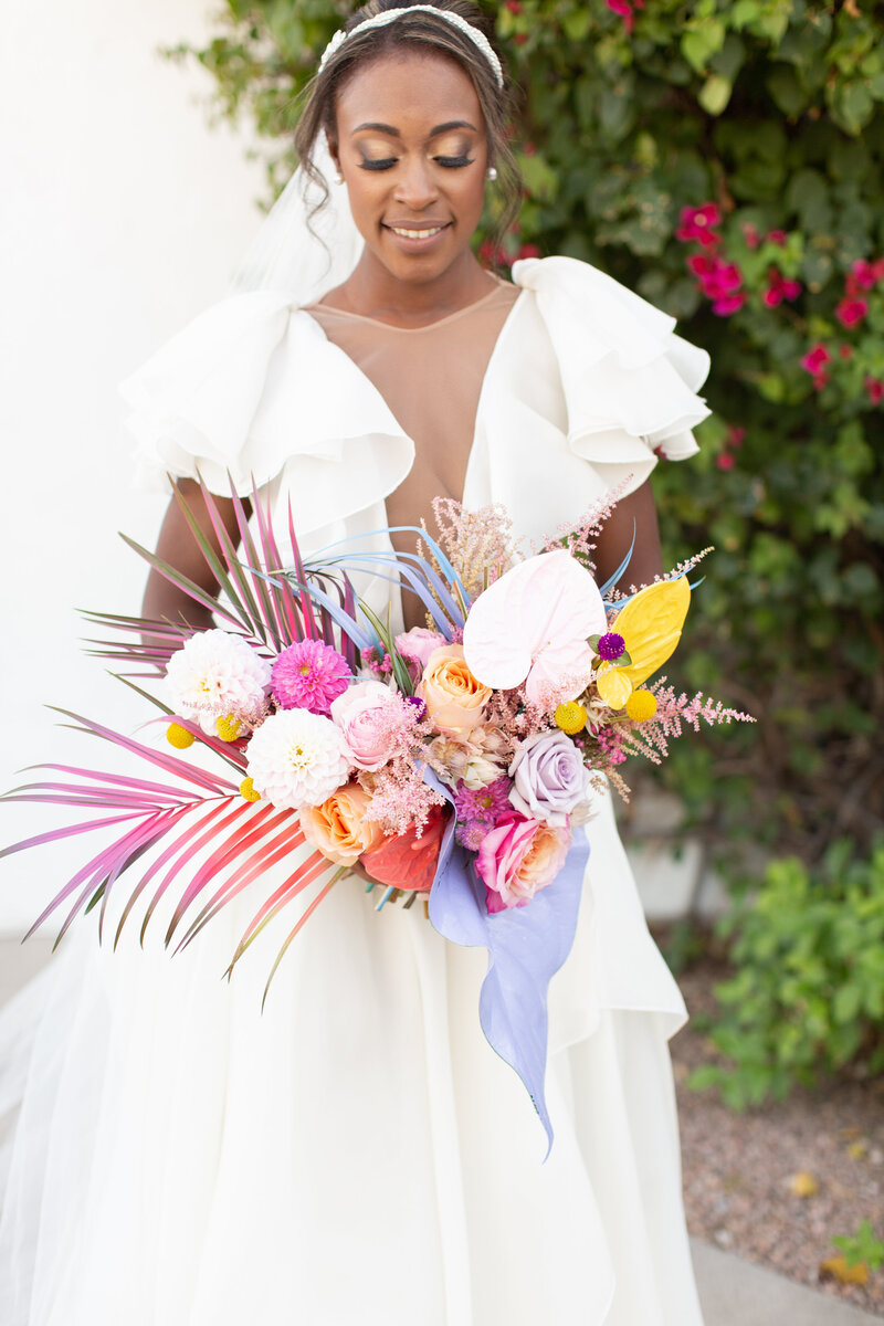 Bride holds rainbow bouquet of flowers
