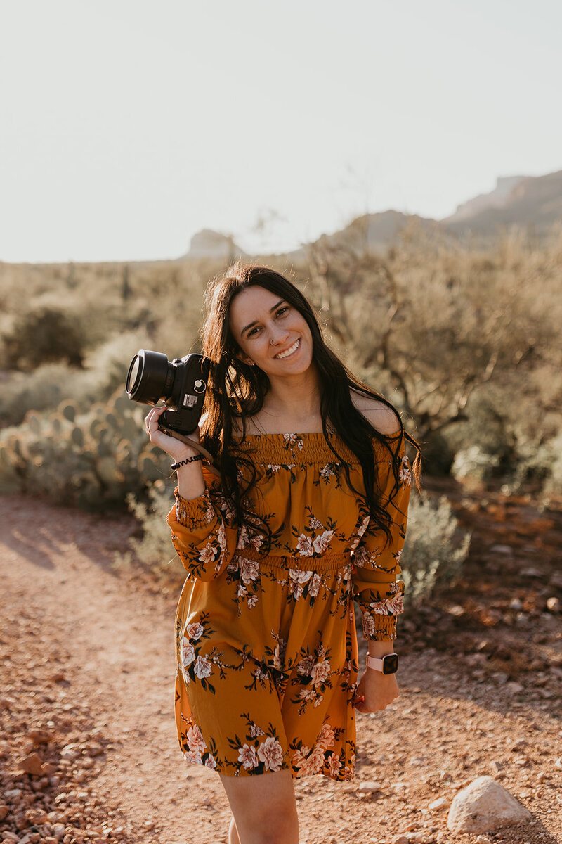 woman walking towards camera with jumpsuit and camera