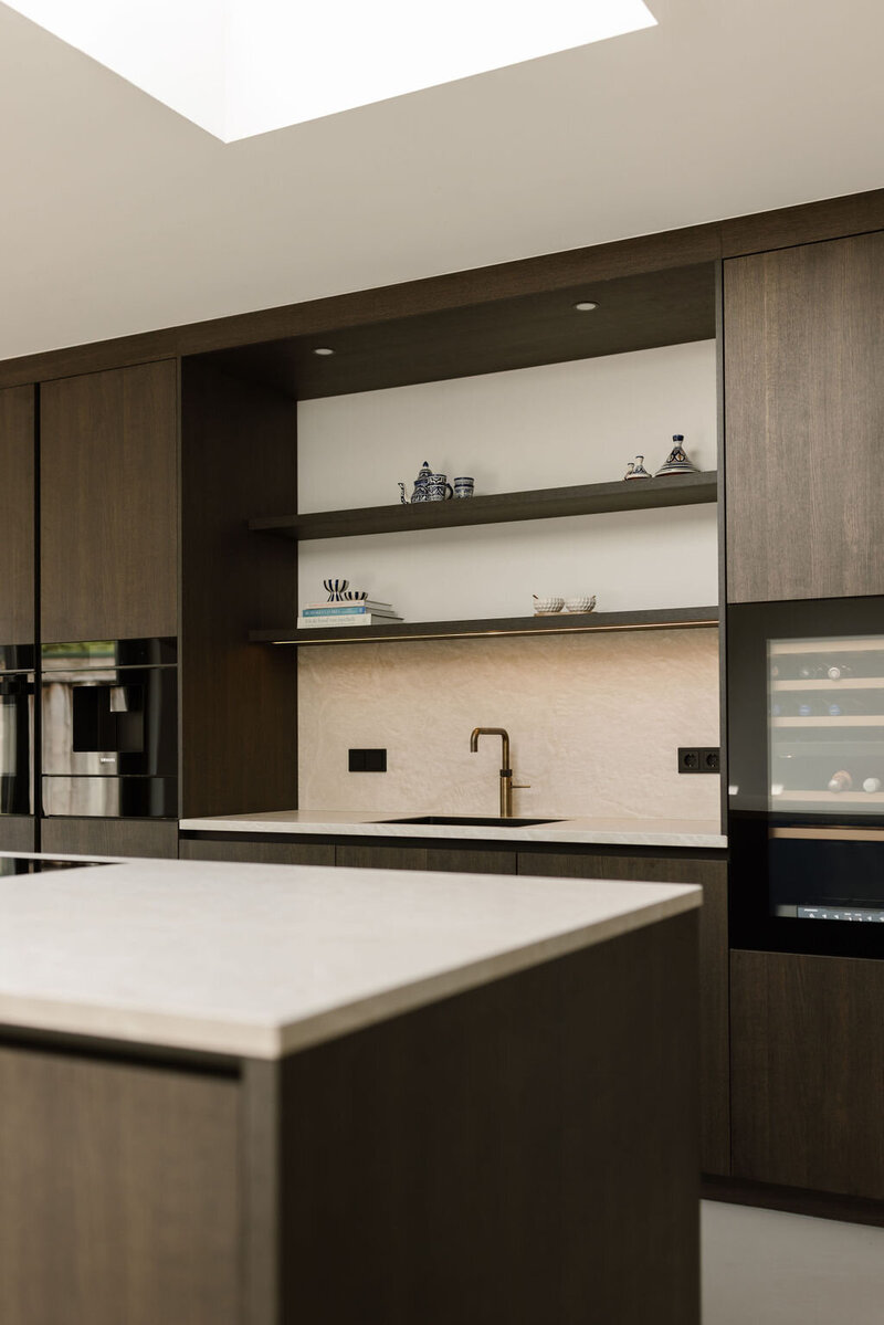 Deze keuken straalt rust en functionaliteit uit, met slimme opbergruimte en verfijnde materialen tot in detail doorgevoerd.