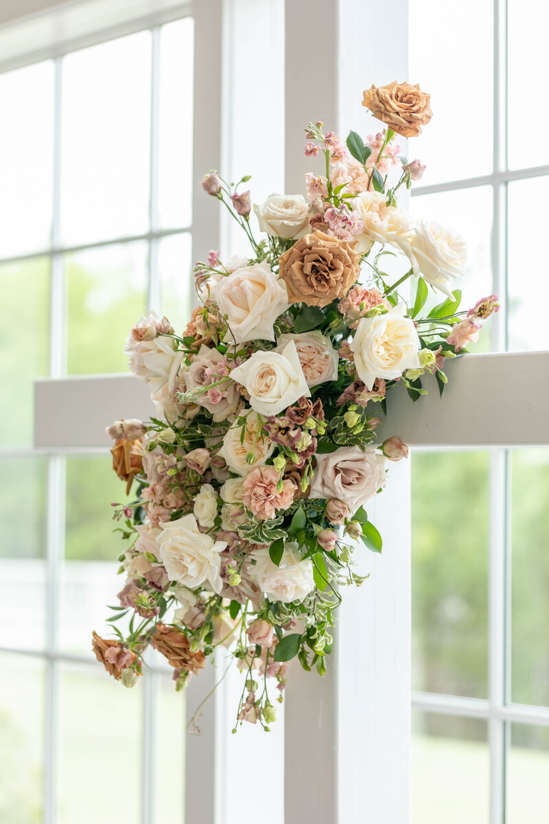 white cross on alter with beautiful flowers