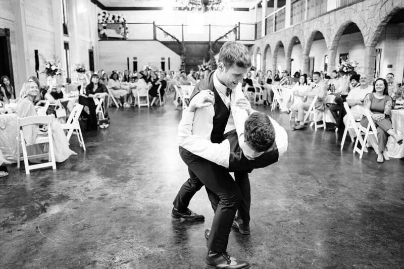 Two grooms happily dancing in their wedding