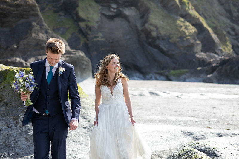 Bride and groom walking on the beaches at Tunnels Beaches in North Devon on their wedding day