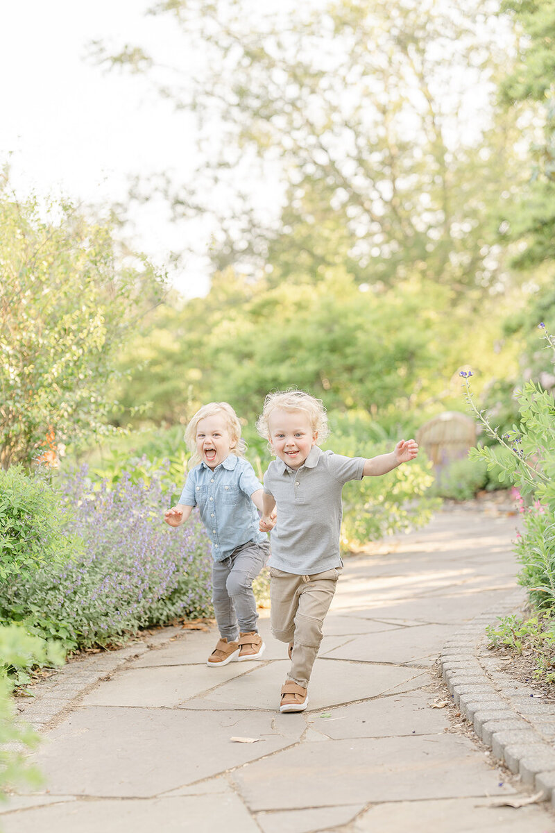 brothers running in the middle of a garden during Alexandria, VA family pictures