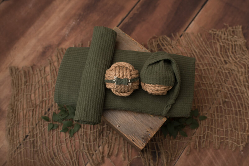 Crate with green wrap, headband and hat on it