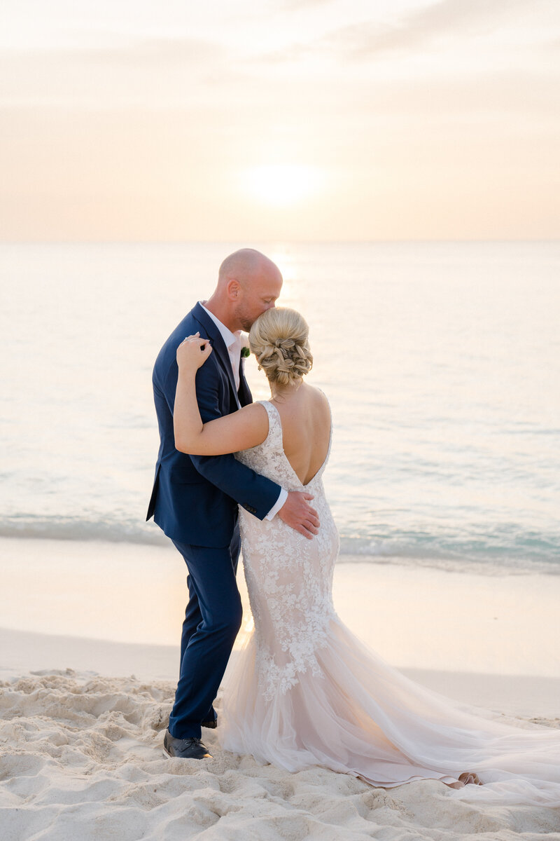 Bride and groom look out over the turquoise ocean in Aruba on their wedding day