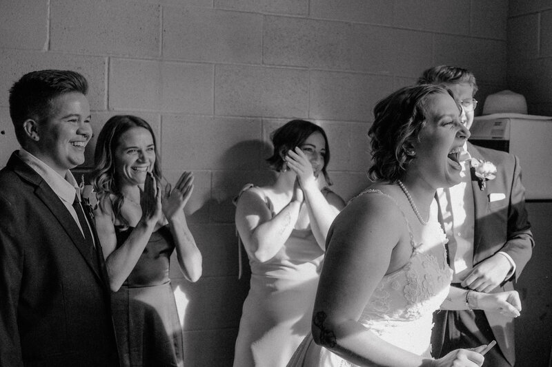 bride and groom with bridal party cheering after signing their marriage license