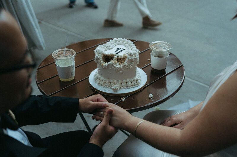 bride and groom holding hands with cake after eloping shot by Elsie Goodman Photography | NYC Elopement Packages