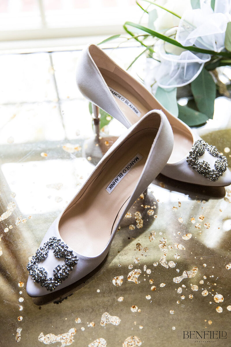 Beautiful white manolo blahnik wedding shoes on a gold mirrored table