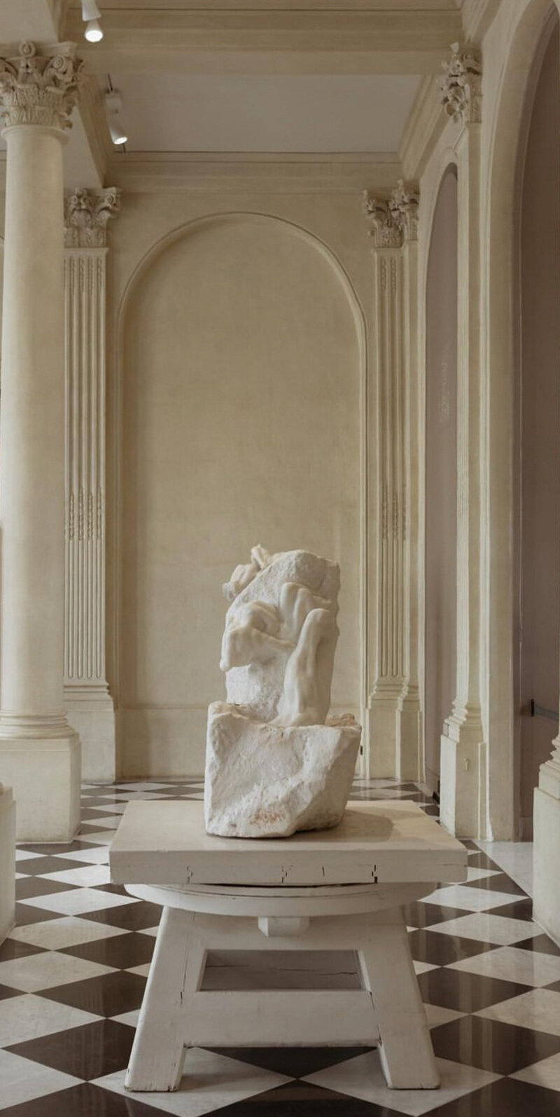 White marble sculpture displayed in a neoclassical gallery, representing originality and artistry in travel.