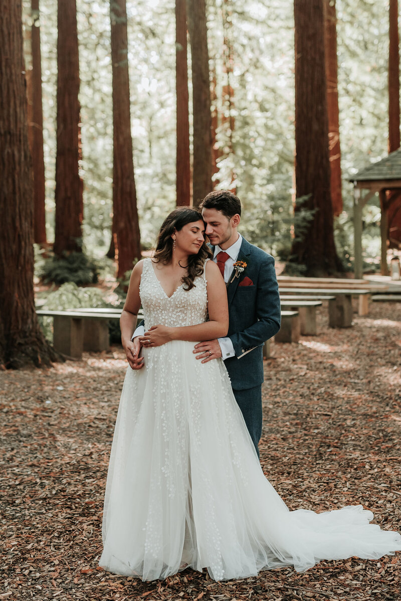 Bride & Groom cuddle into each other in the woods at Two Woods Estate