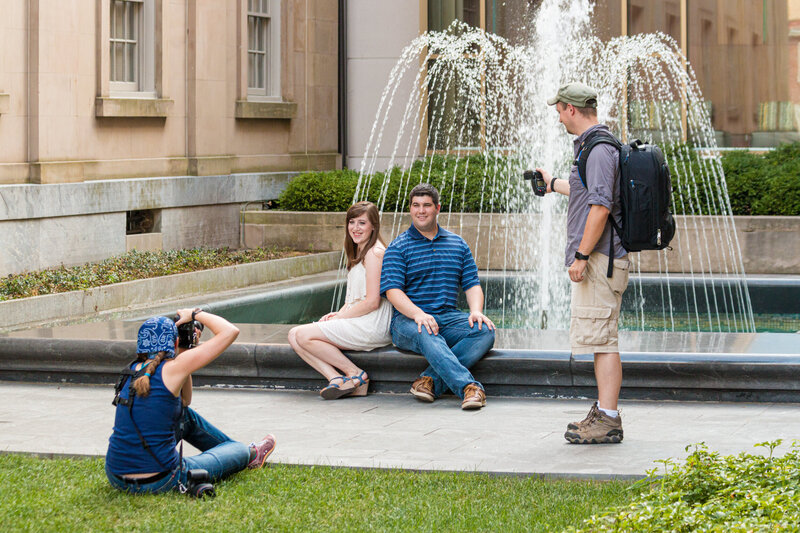 Jen and Travis Stitt capturing a romantic moment with an engaged couple in the vibrant streets of downtown West Chester during an engagement session, blending urban charm with timeless photography expertise.
