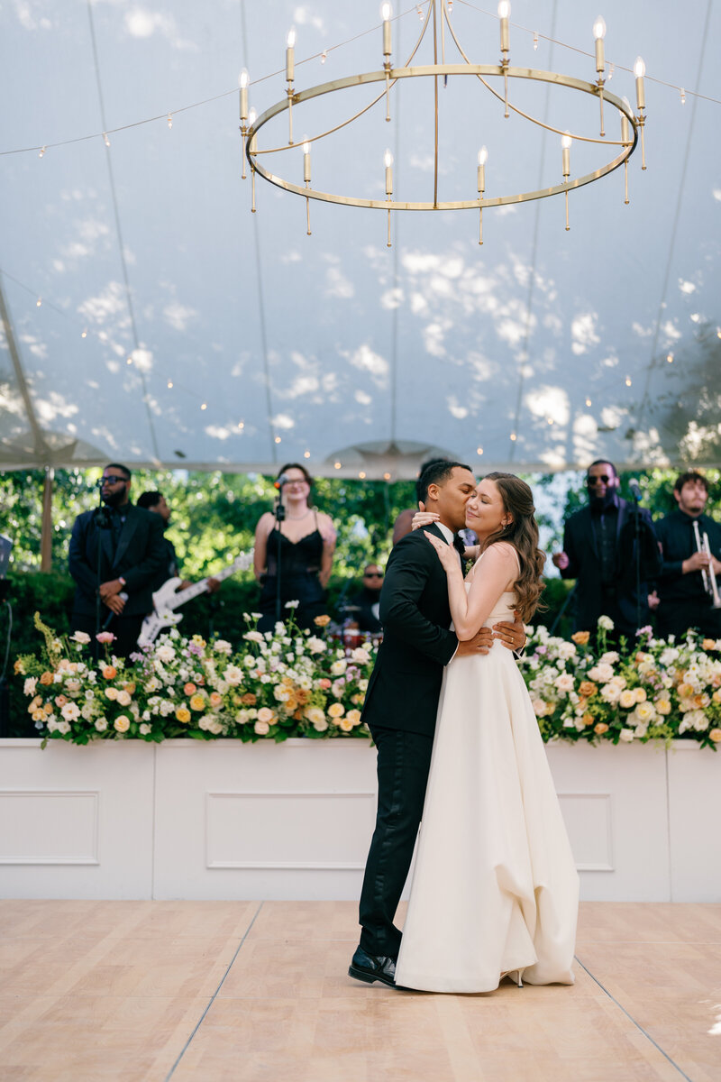 Bride and groom kissing during outdoor wedding ceremony