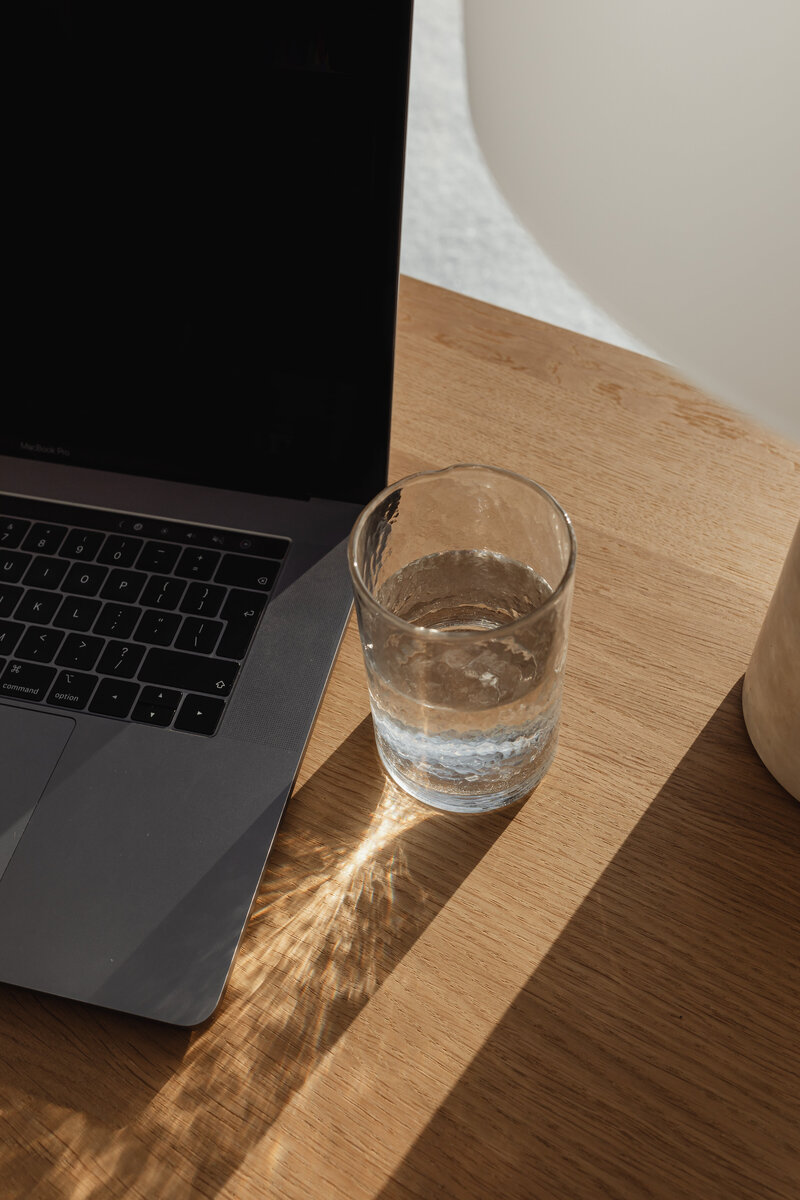 Latina web designer sitting at a coffee shop working on laptop 