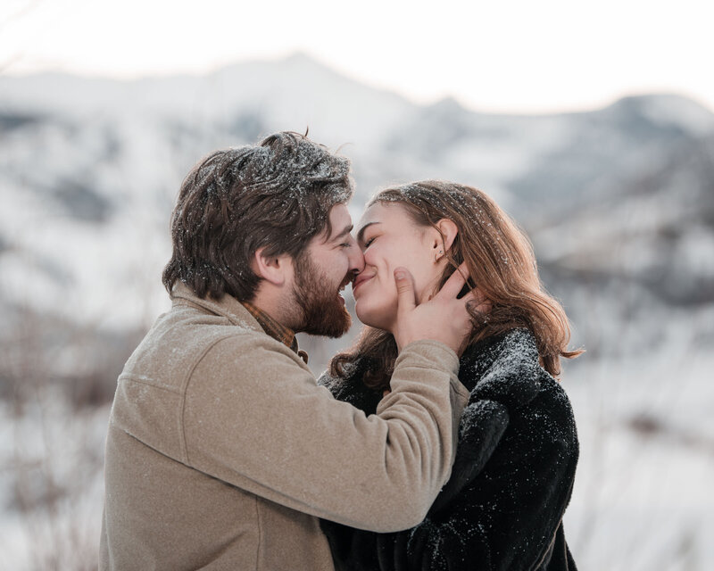 Couple sharing a playful lift with Maroon Bells behind them