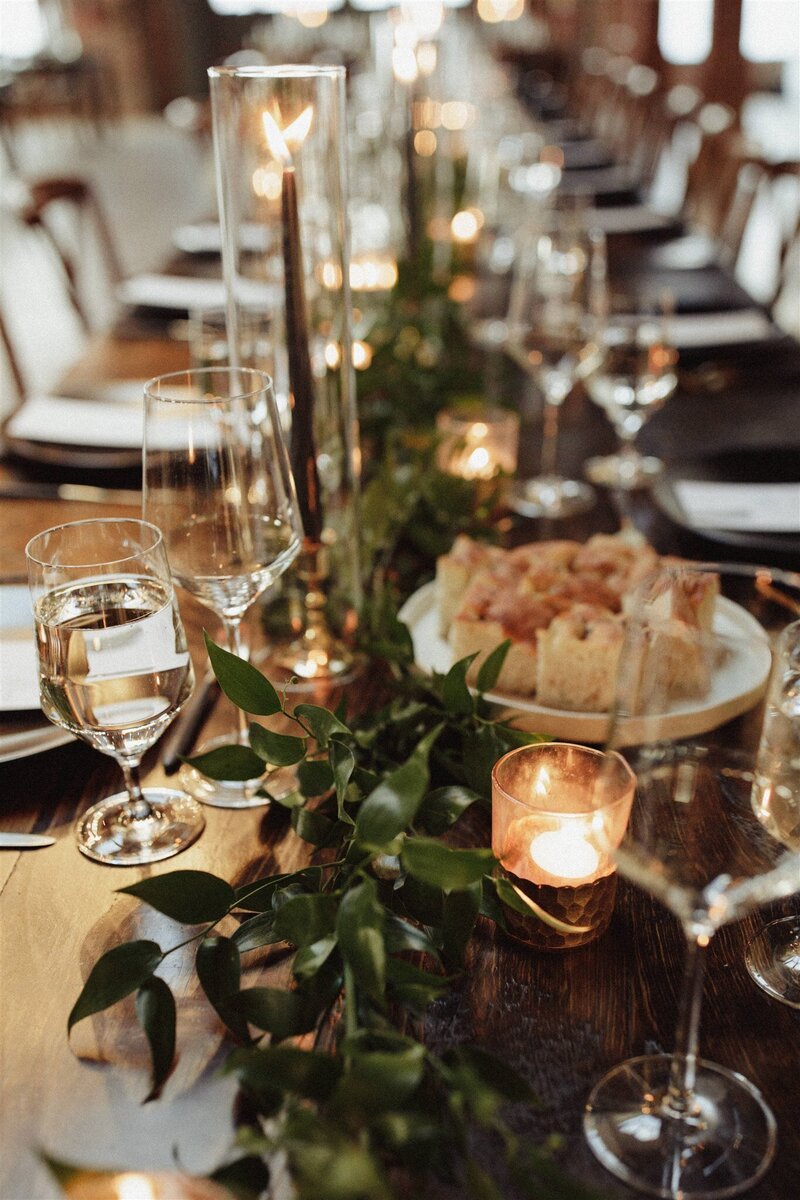 wedding reception tablescape with candles and greenery