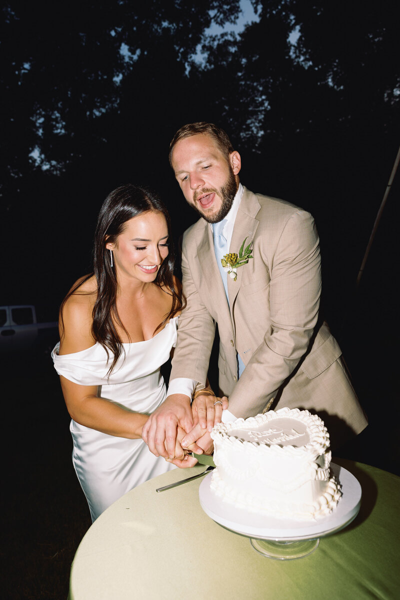 Bride and groom flash photography of cake cutting at coastal new england wedding