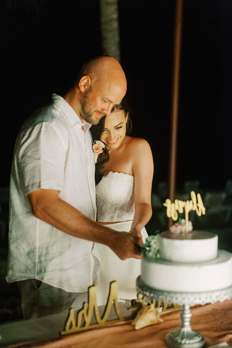 Newlyweds share a sweet moment while cutting their two-tier wedding cake.