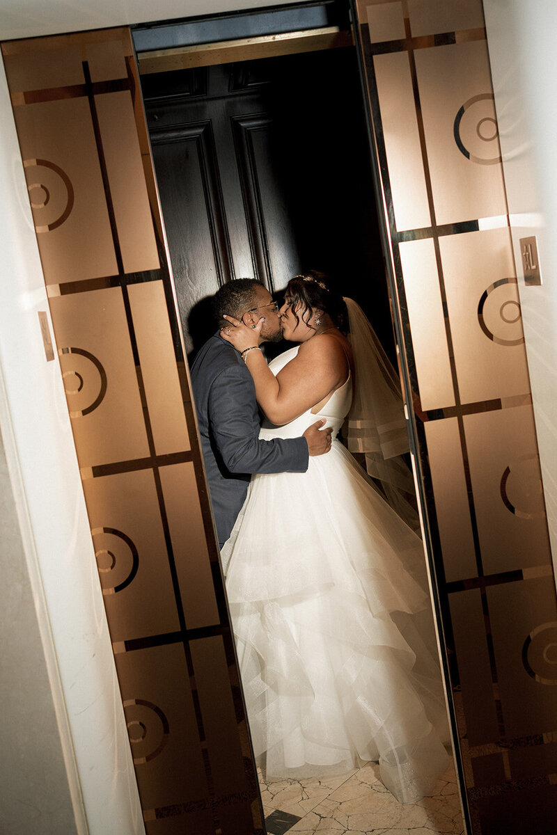 newlyweds kiss in elevator wedding day