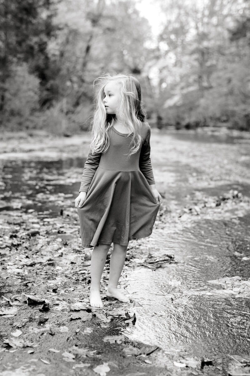 Black and white photo of little girl standing by Nashville river