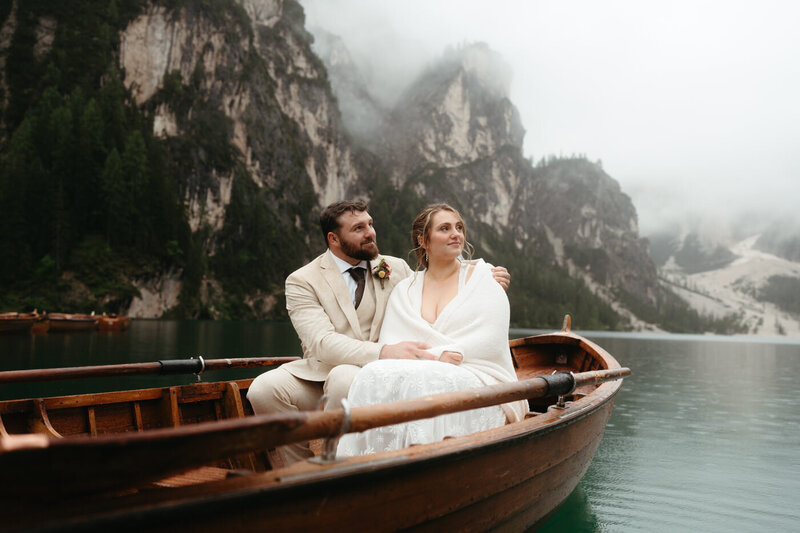 Bride and groom sitting on a rowboat on Lago di Braies during their Dolomites elopement