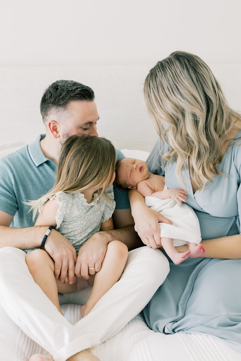 similing family of four during an in-home lifestyle session in Charlotte NC, with natural light and neutral tones