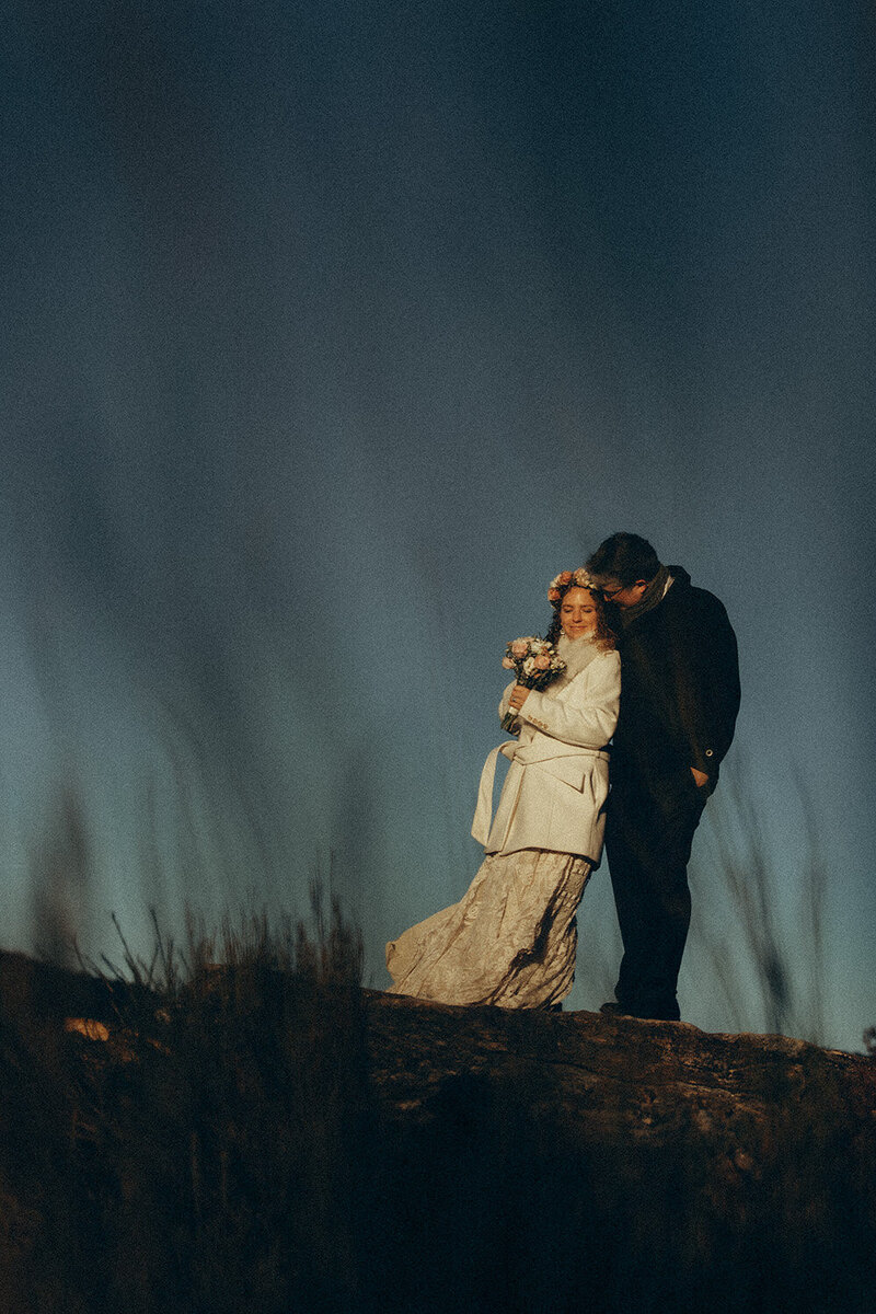 Natural elopement photography capturing a bride resting intimately during a candid moment on her groom's chest