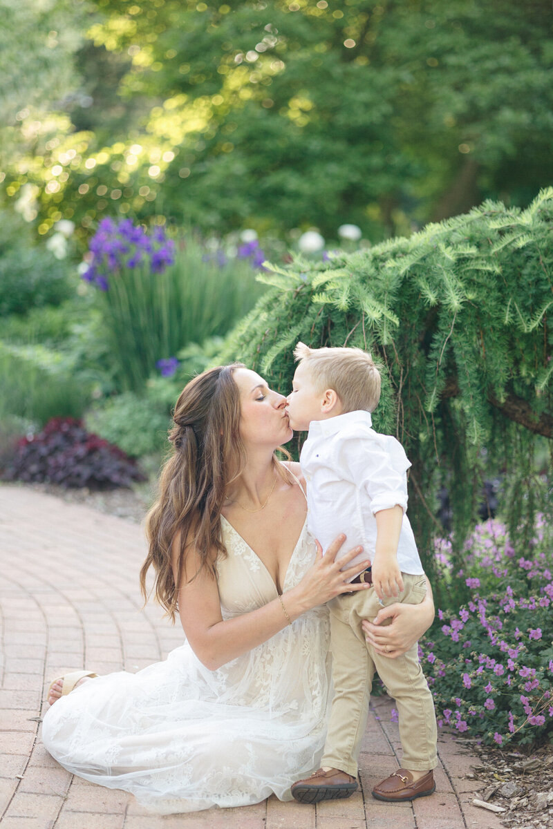 Portrait of a mom kissing her son in a garden taken by louisville maternity photographer missy marshall
