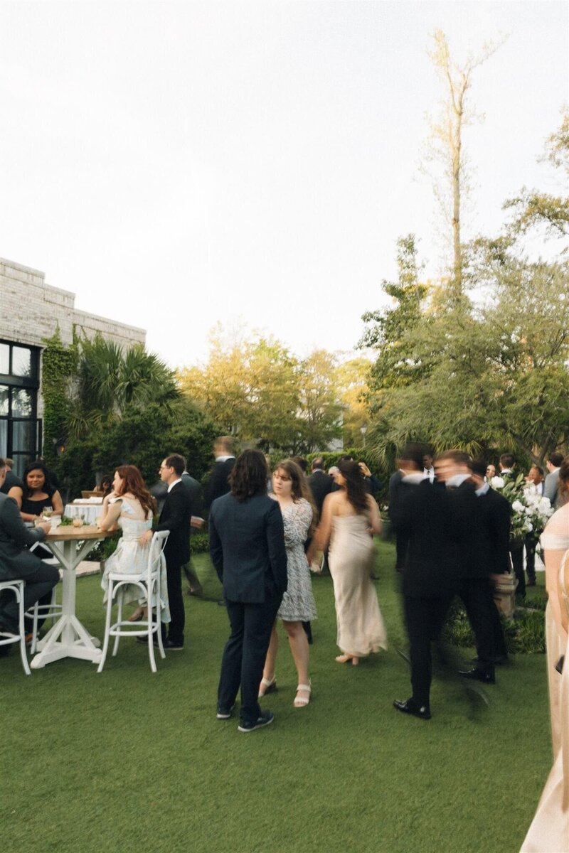 A moment captured during an active cocktail hour outside in a garden 