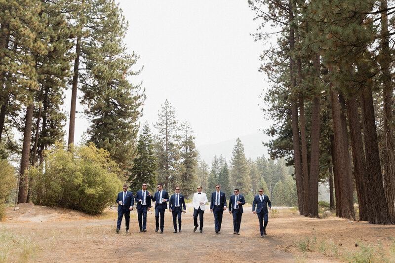 Groomsmen in matching suits strolling through a forest, captured by T+M Photo (TM Photography), a Sacramento professional photographer known for in the moment wedding and lifestyle photography.