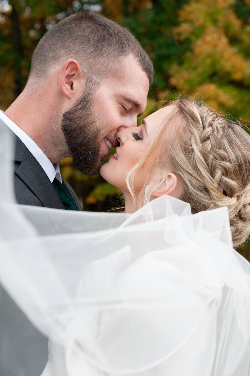 married couple about to kiss during their rustic fall wedding at private estate in Port Huron, MI
