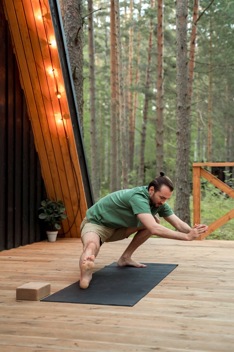 A man effortlessly assumes a standing yoga pose