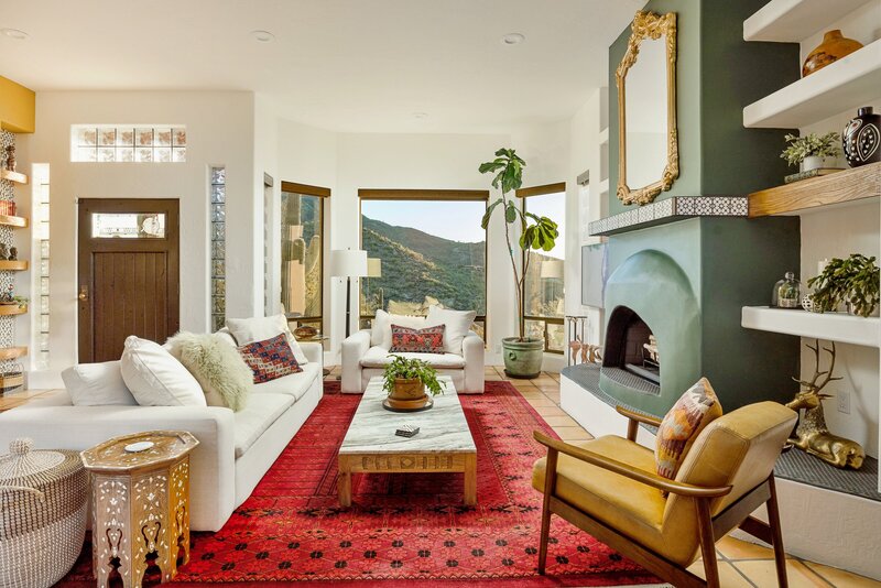 Cave Creek home for sale with a colorful living room featuring a bright red rug, green fireplace, and views of Black Mountain.