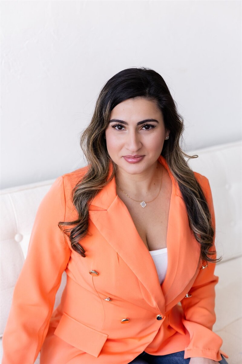 Yudielis Sánchez sonriendo  con blazer naranja.