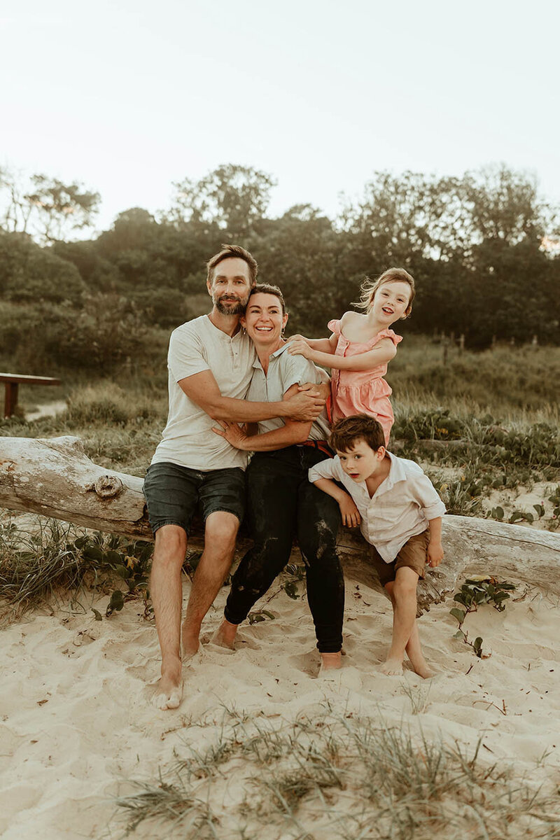 Liz & Dan - family sitting on a log at the beach