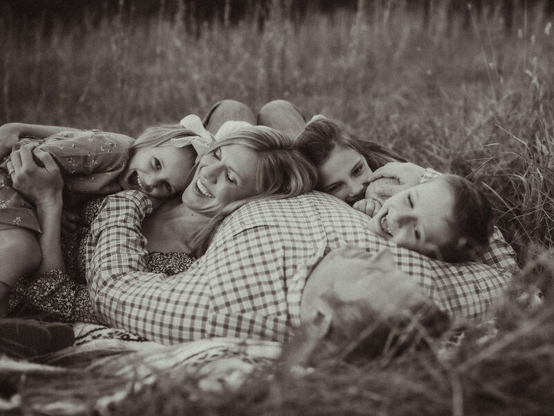 A family piles up on a blanket together at The Vine Photography Venue in Acworth, GA. 