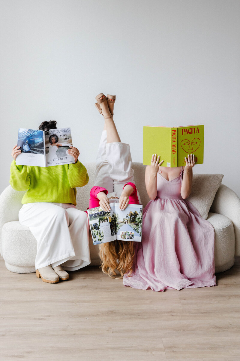 Our wedding dream team goofing off with wedding magazines, laughter and electric energy in every glance
