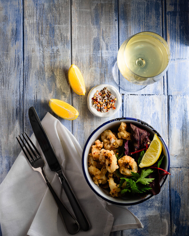 Bowl of calamari with a glass of white wine